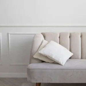 beige fabric couch upholstery in a minimalist modern living room with clean white wall.