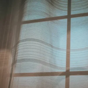 blue sheer curtains diffusing natural light through window