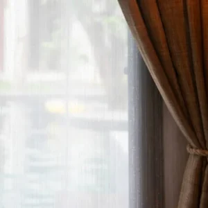 brown linen curtain with inner sheer layer near bright window