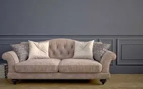 Classic tufted fabric sofa with cushions placed against a dark grey wall in a stylish Dubai home.