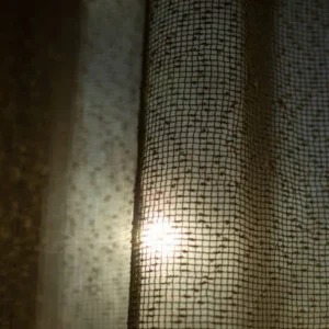 close up of fine weave curtain fabric with sunlight shining through