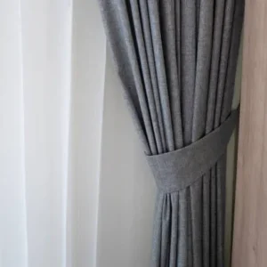 grey linen curtain with structured tieback detail near wall