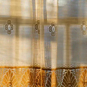 mesh weave curtains with decorative border and sunlight