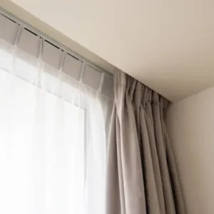 motorized curtains installed on corner window with sheer and fabric layers