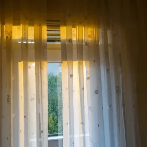 sheer curtains with floral pattern filtering sunlight through window