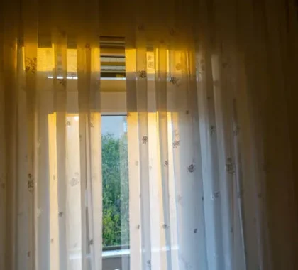 sheer curtains with floral pattern filtering sunlight through window