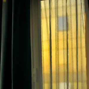 sheer curtains creating warm sunlight shadow patterns inside room