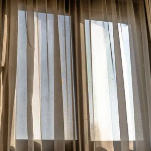 sheer curtains covering wide apartment window with natural daylight