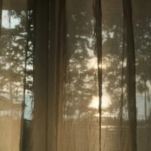 sheer fabric curtains with sunlight passing through near window view