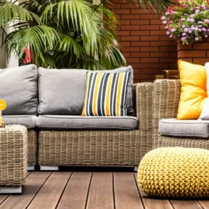 wicker outdoor sofa with white cushions in modern patio setting.