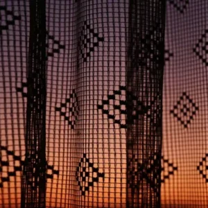 woven curtains with geometric pattern and sunset light behind