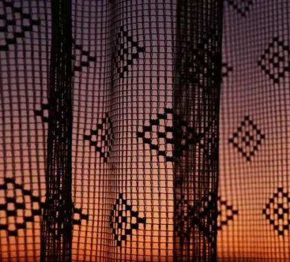 woven curtains with geometric pattern and sunset light behind